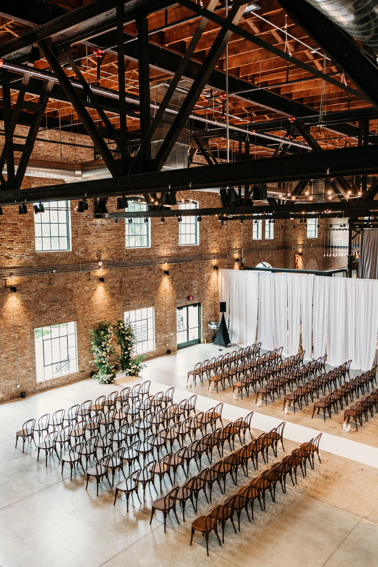 Atrium ceremony with floral arch and natural light